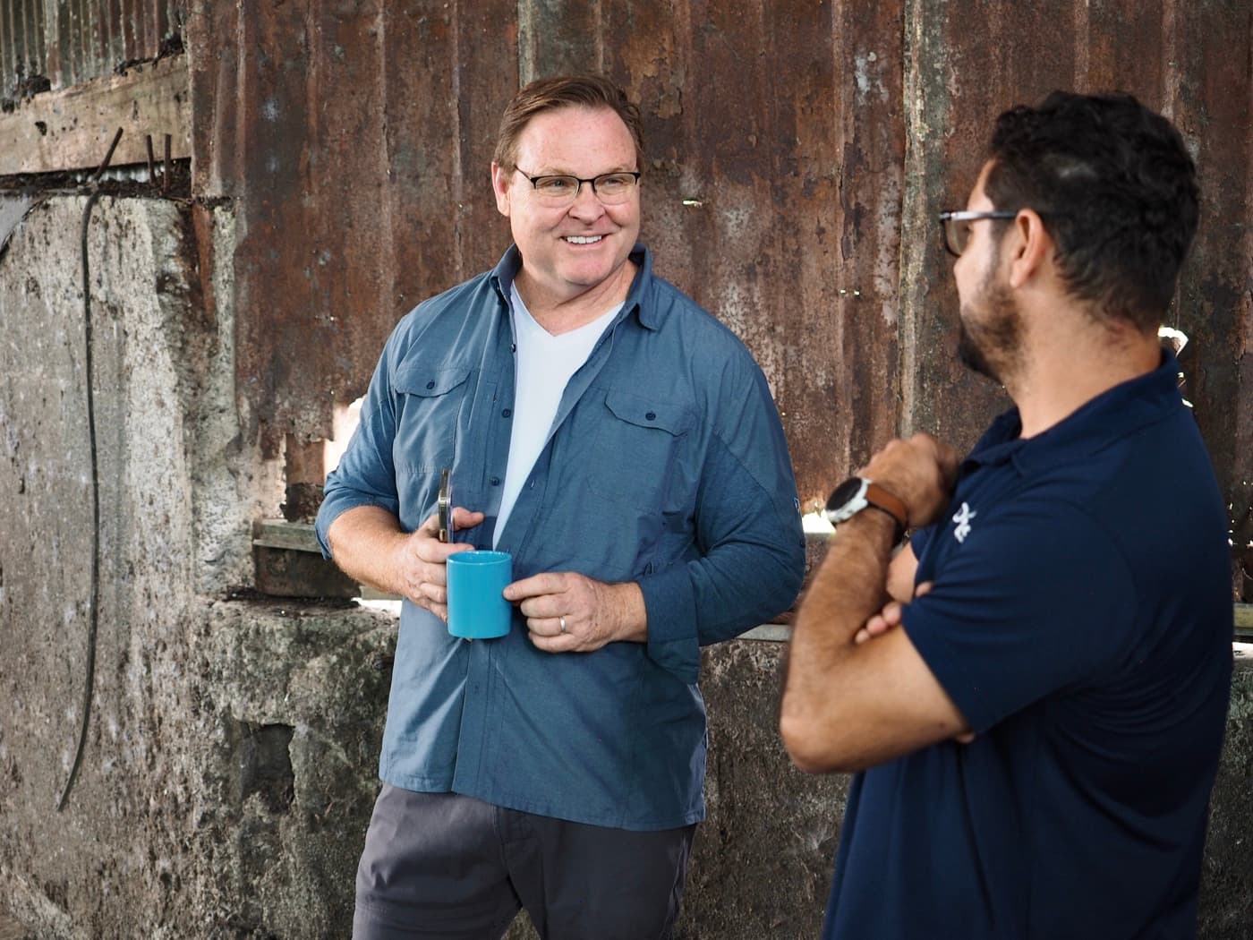 David Griswold at a coffee mill, talking with project leads